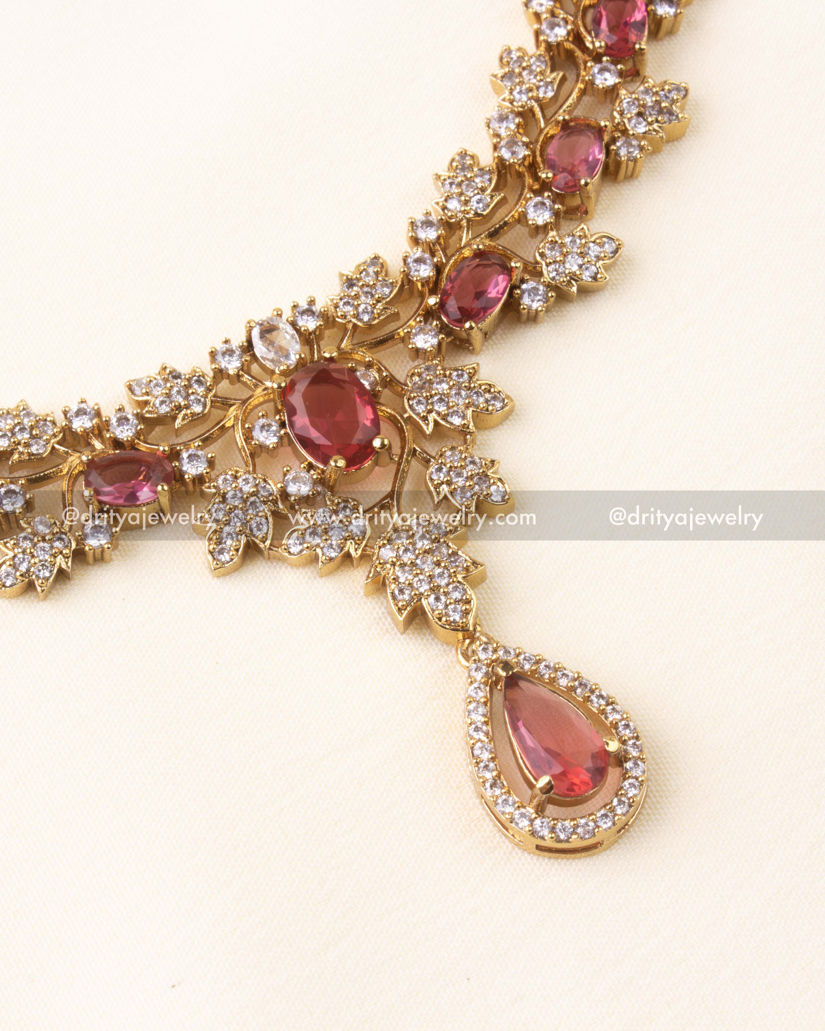 Pendant view showing teardrop ruby red stone framed with white CZ stones.