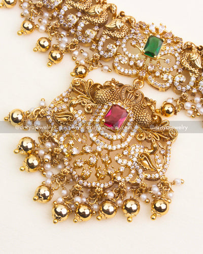 Detailed antique short necklace pendant with red CZ stone, floral Nakshi work, and pearl-gold danglers.