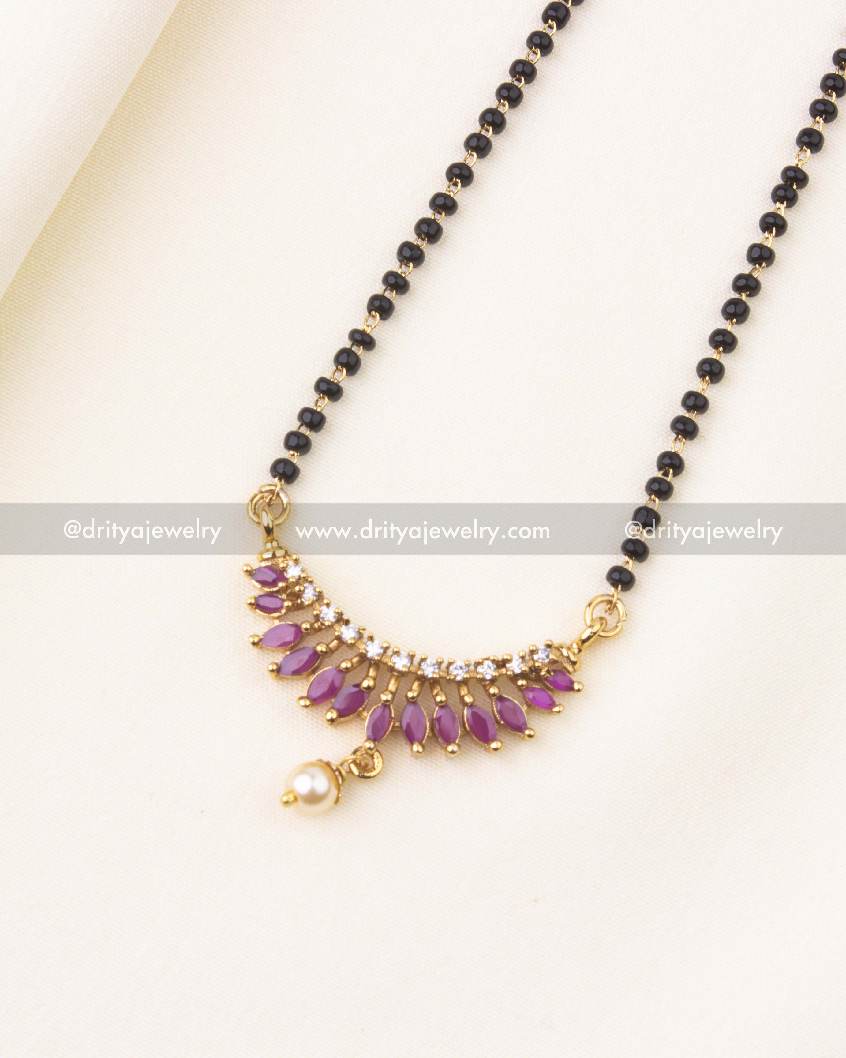 Detailed pendant with pink accents, CZ stones, and pearl drop on black beads chain.