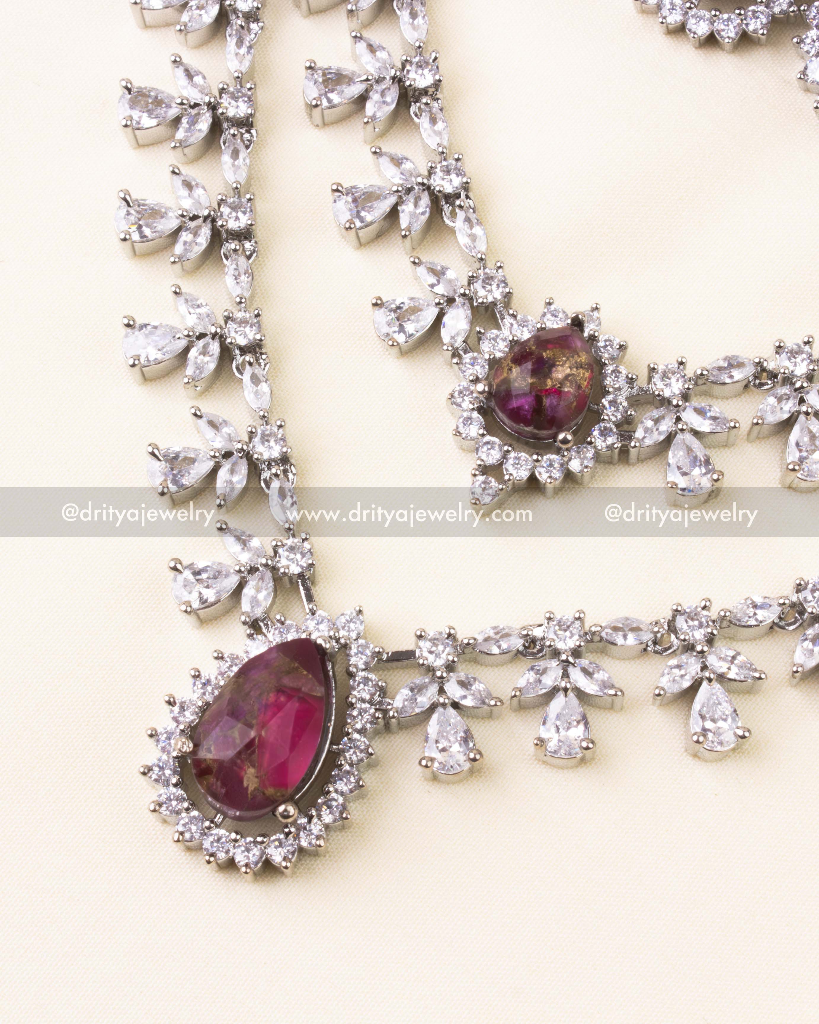 Deep magenta stone pendant with zircon halo and matching layered necklace.