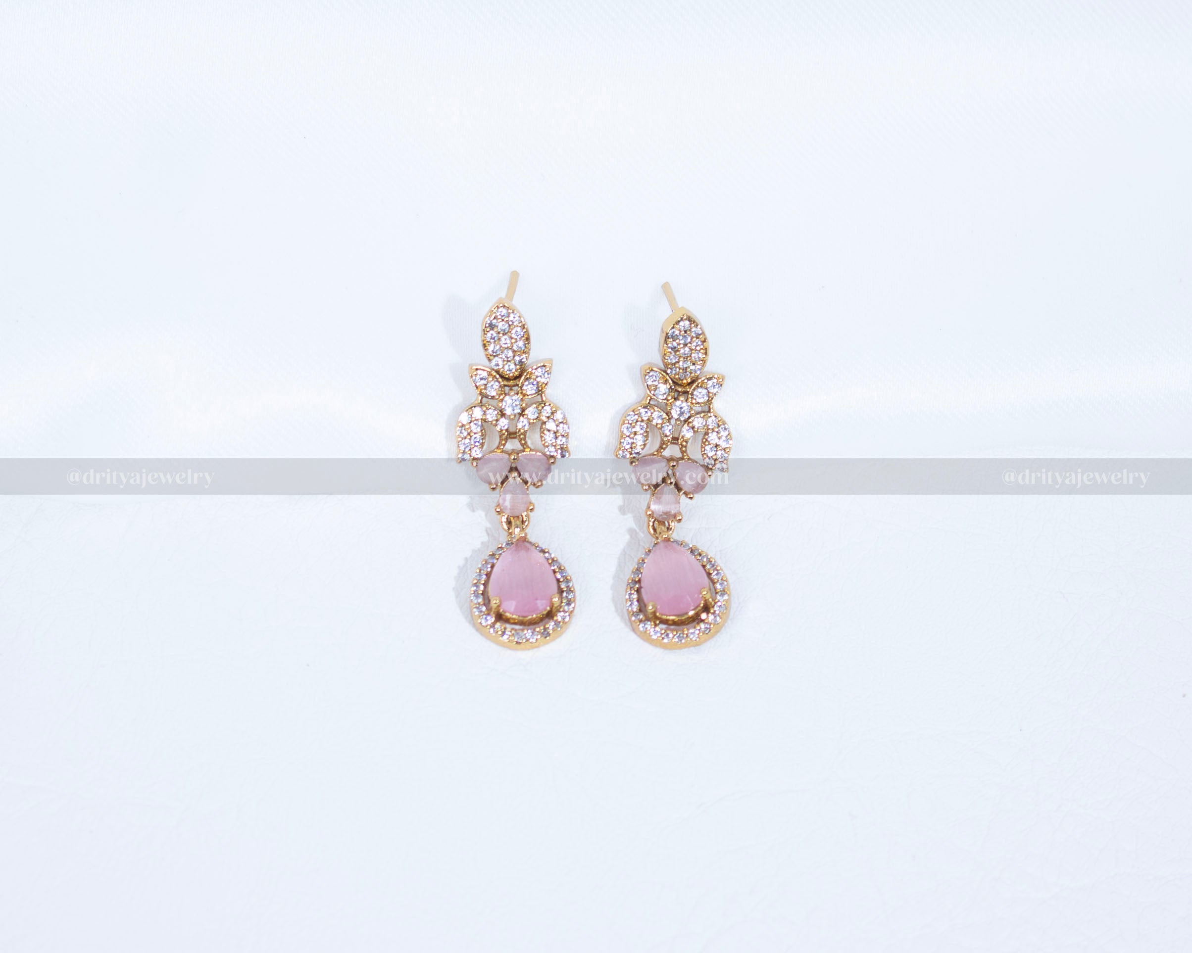 Close-up of Dritya Jewelry’s matching drop earrings from the pink stone necklace set, showcasing pink stones and CZ detailing for an elegant look.