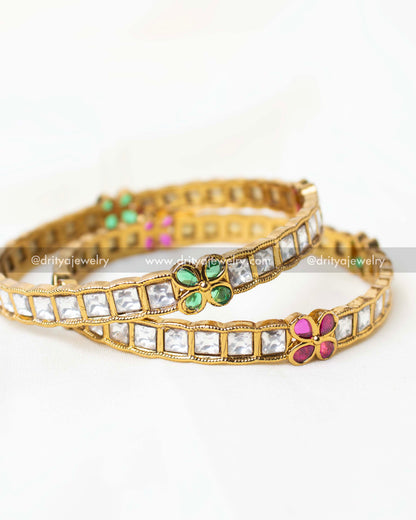 Detailed view of moissanite-inspired bangles with vibrant pink and green floral motifs.