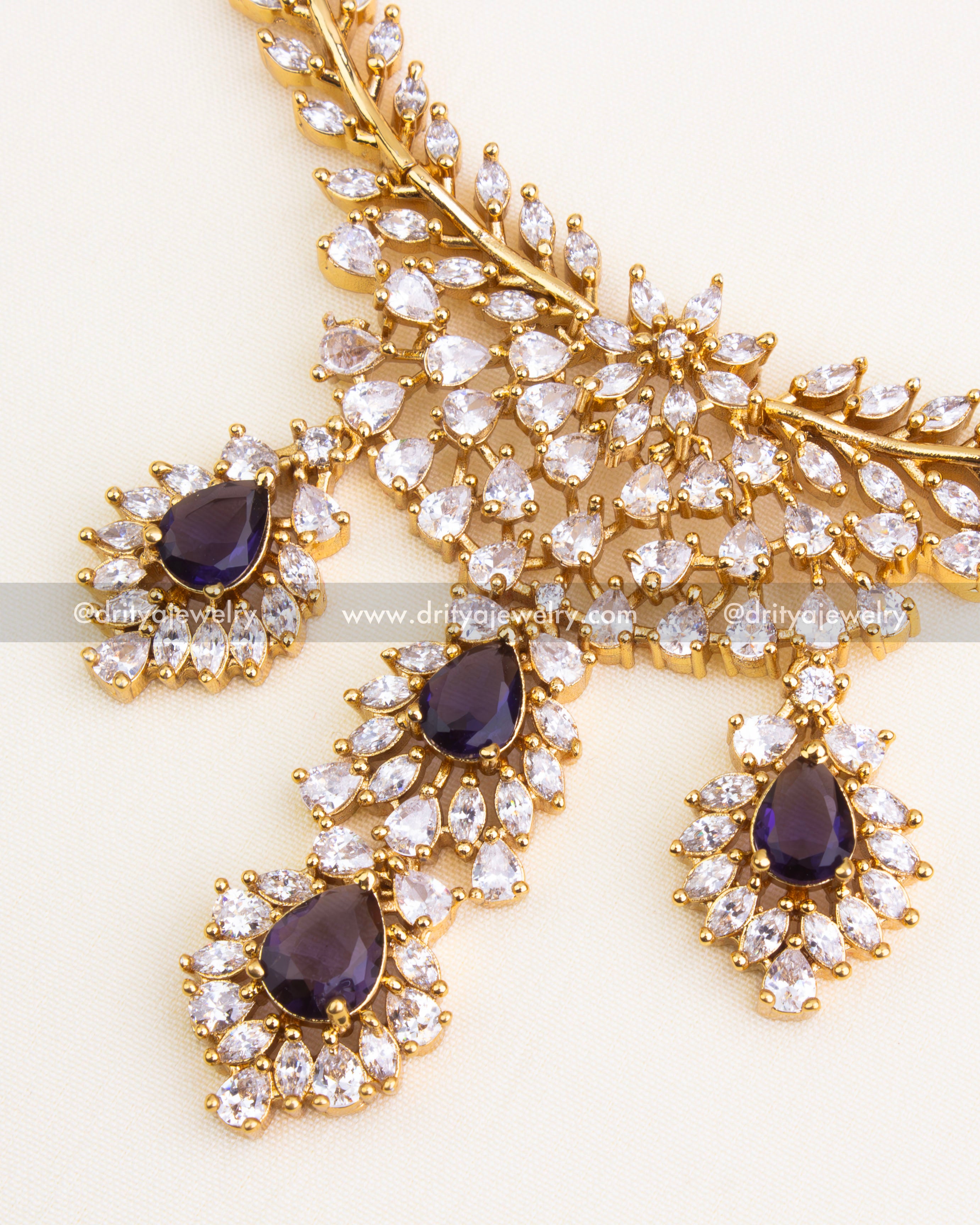 Gold-plated floral motifs with purple stones and CZ settings.