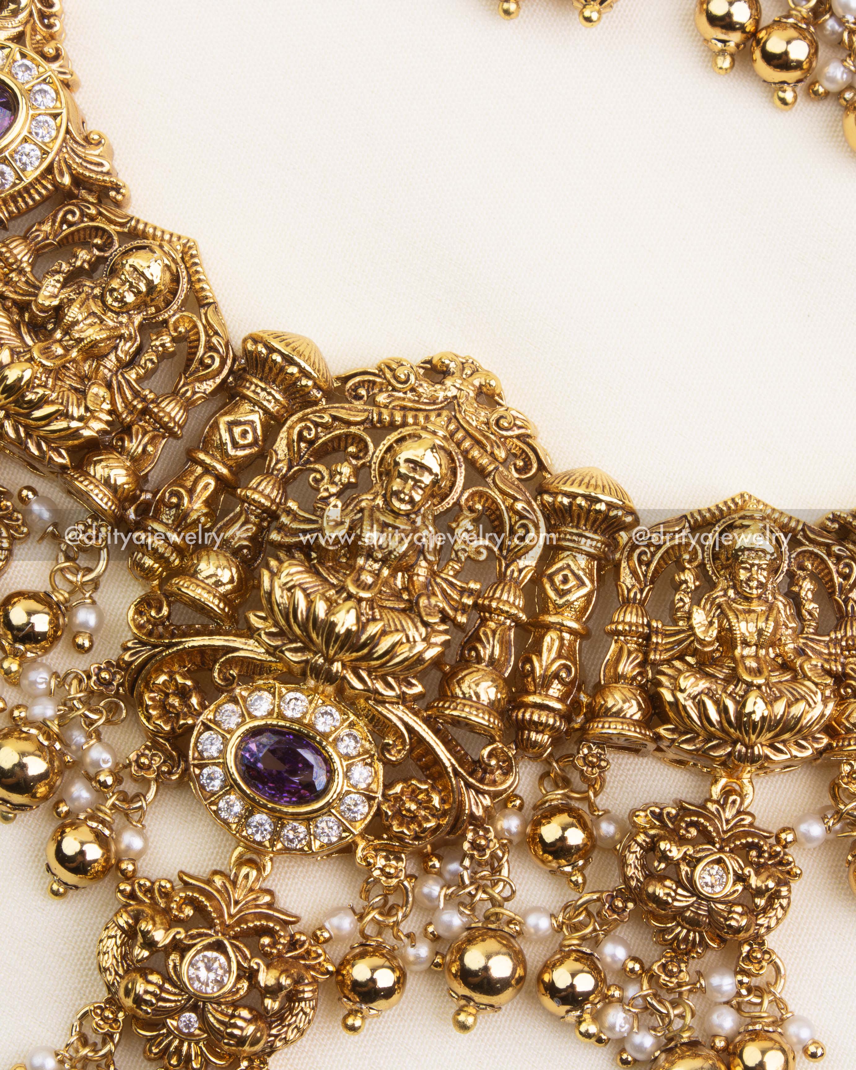 Detailed pendant with Lakshmi idol, purple accents, and CZ stones.