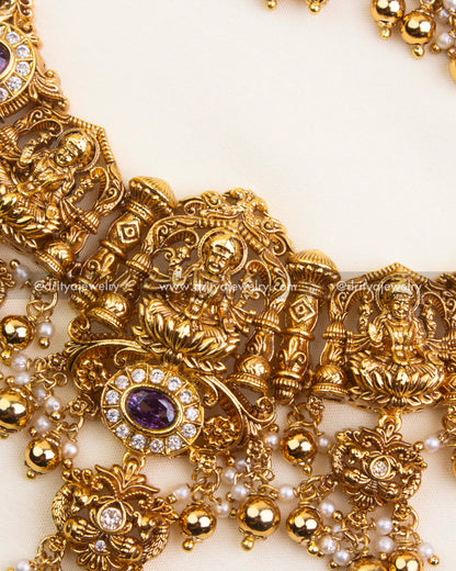 Detailed pendant with Lakshmi idol, purple accents, and CZ stones.