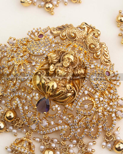 Ornate Lakshmi pendant featuring CZ embellishments, purple gemstone, and traditional pearl clusters.