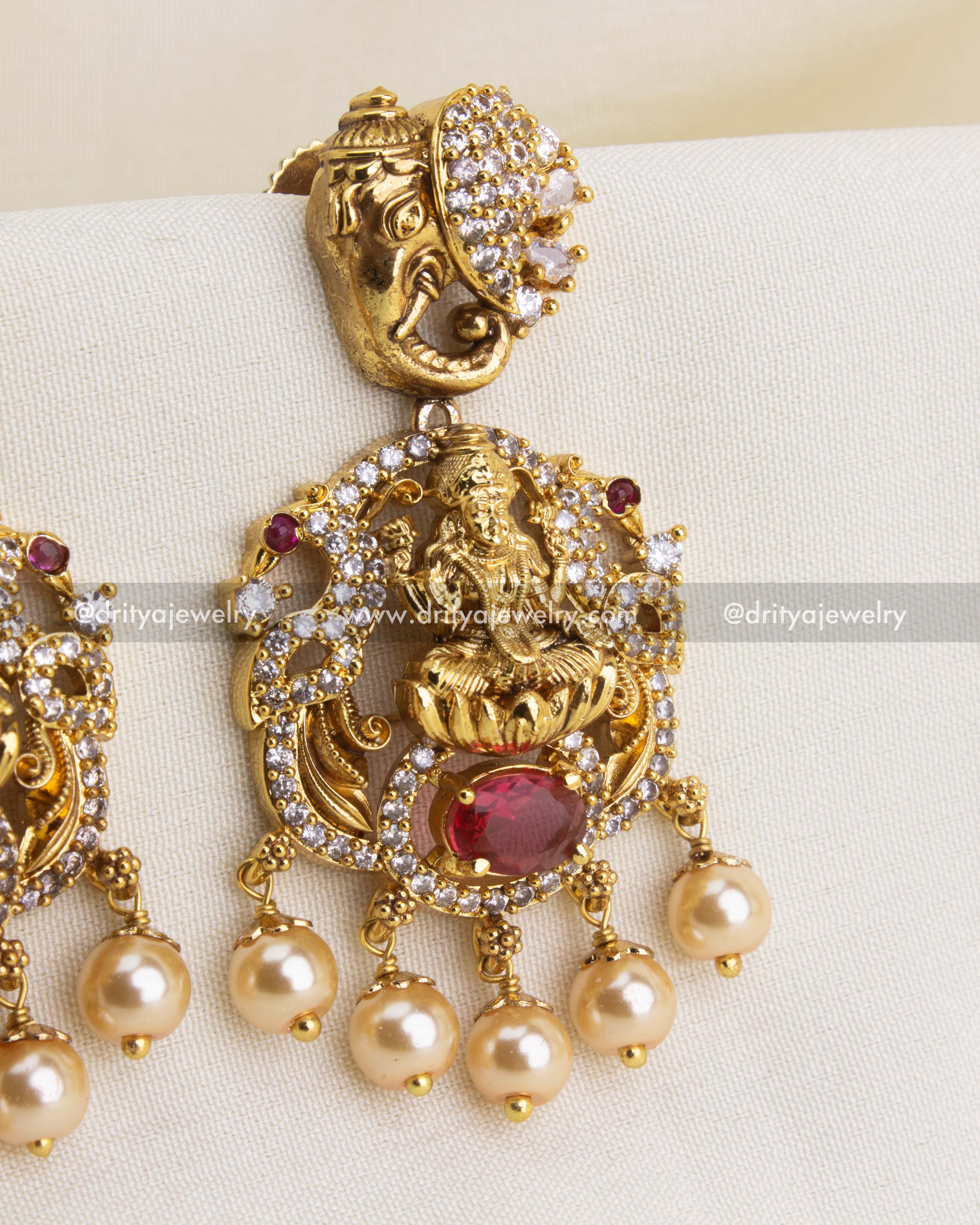 Detailed close-up of Lakshmi temple danglers with ruby-red stone and pearl drops.