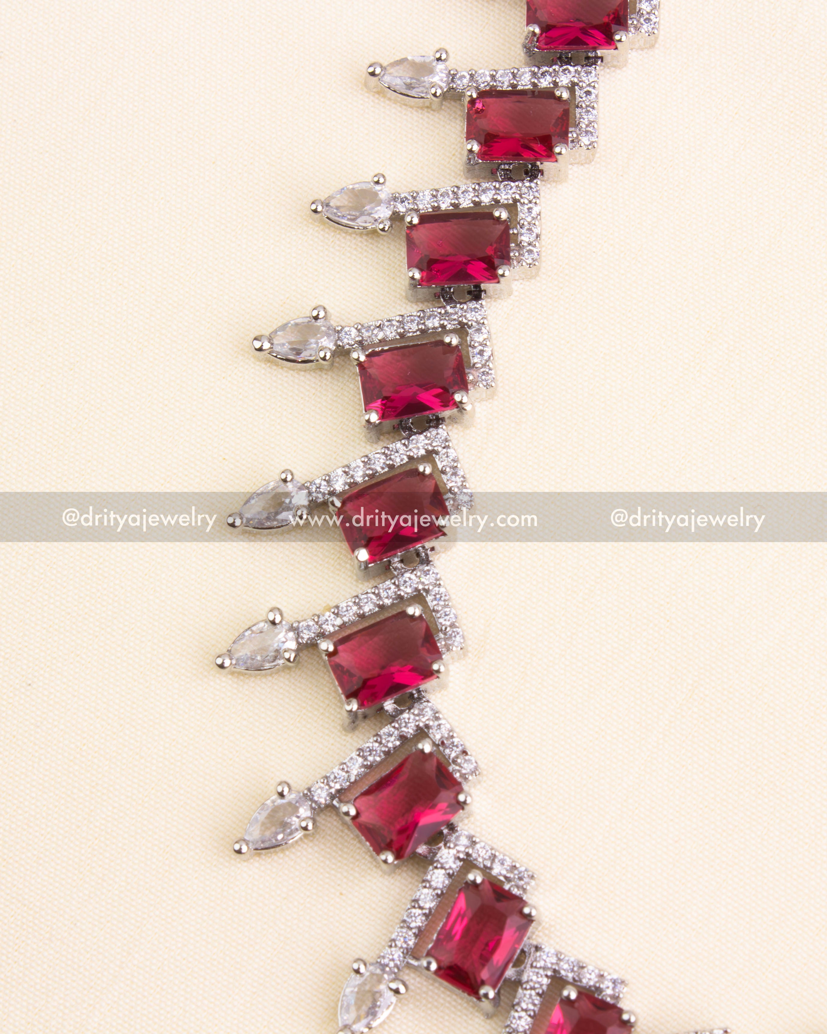 Emerald-cut red stones bordered with CZ and teardrop embellishments