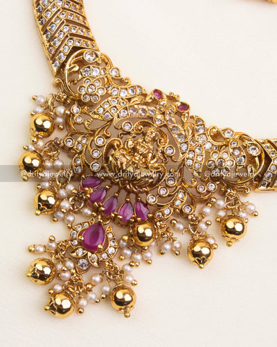 Detailed pendant view with Lakshmi idol, CZ stones, and red teardrop accents.