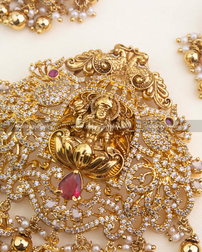 Premium Lakshmi pendant with antique-style gold detailing, studded CZ stones, and ruby-red gemstone.