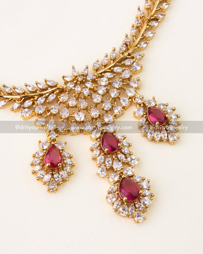 Ruby red teardrop stones surrounded by CZ diamonds in gold setting.