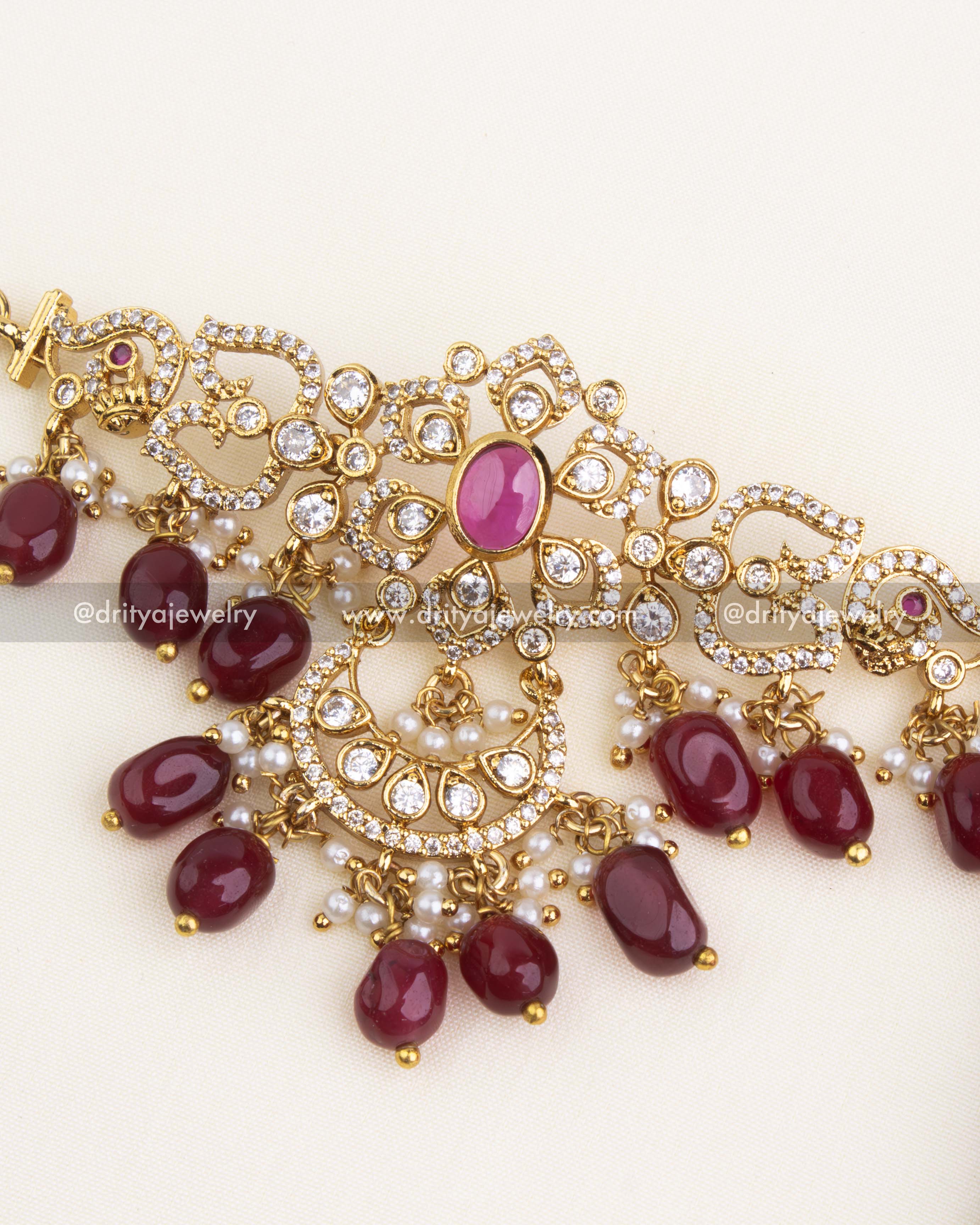 Detailed floral choker with gold finish, red beads, and pearl hangings.