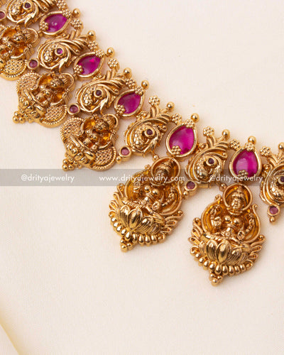 Detailed haram showcasing Lakshmi motifs, floral engravings, and vibrant red stones.