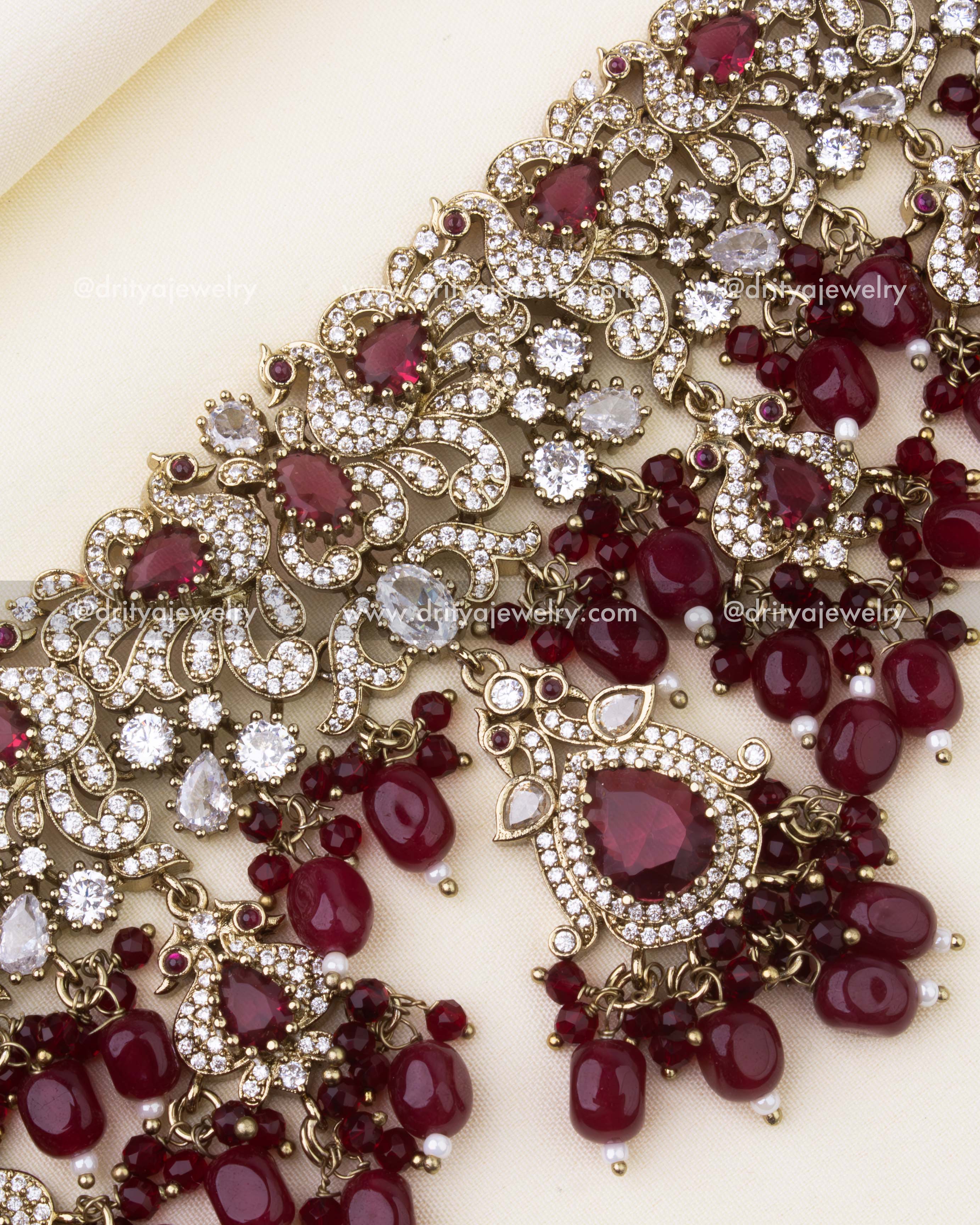 Detailed close-up of ruby red Victorian choker with CZ stones and bead clusters.
