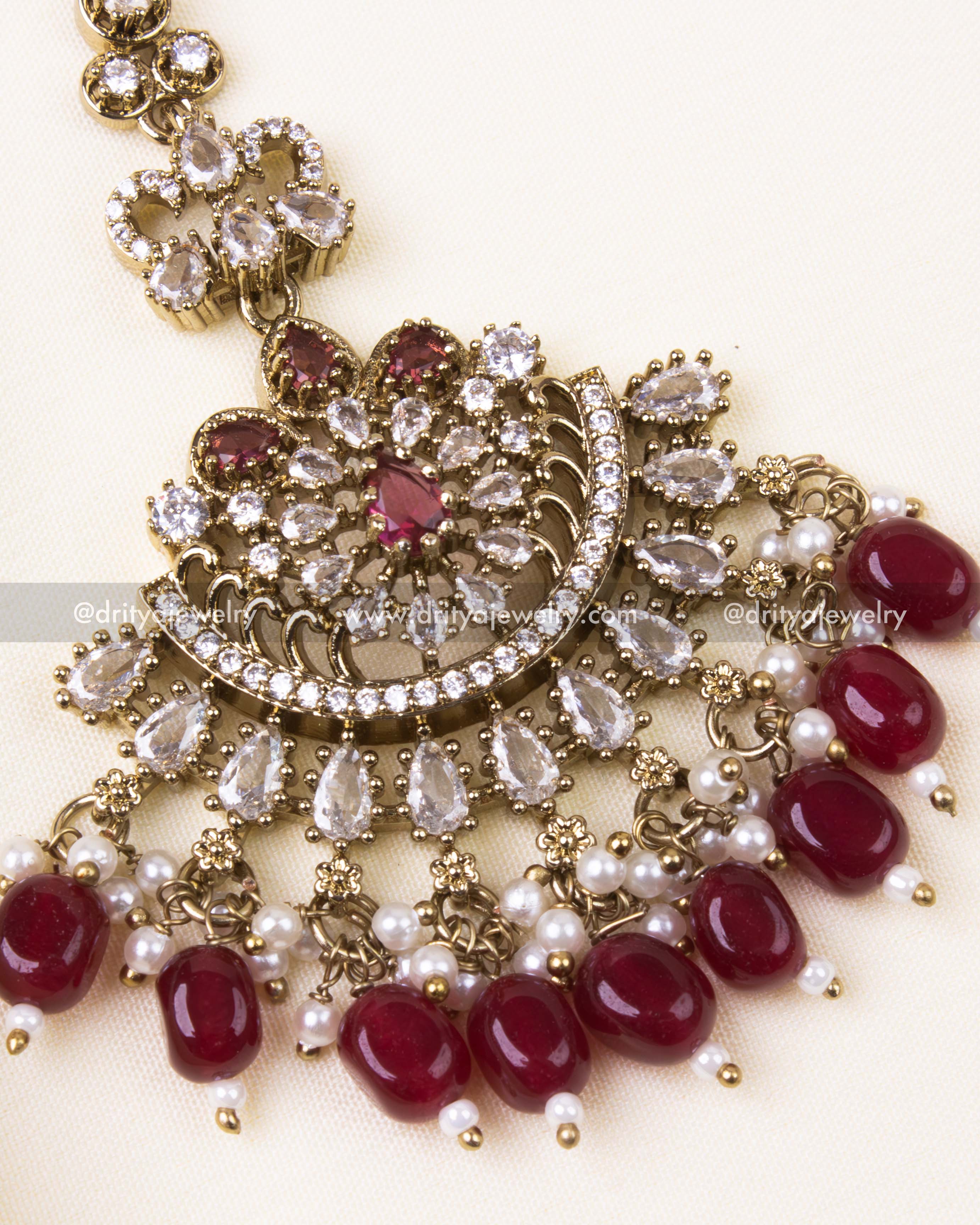Detailed Victorian-style maang tikka with red beads and pearl hangings.