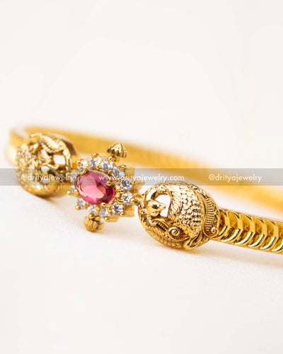 Detailed ruby CZ centerpiece with peacock ends and clear CZ accents.