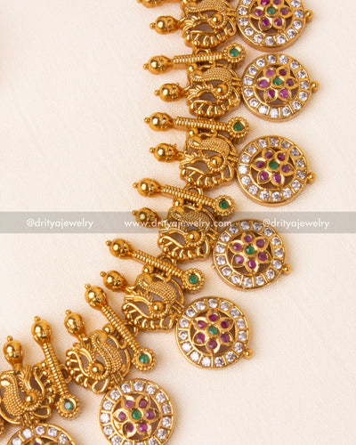 Detailed craftsmanship of gold-plated long necklace featuring traditional motifs and vibrant stone accents.