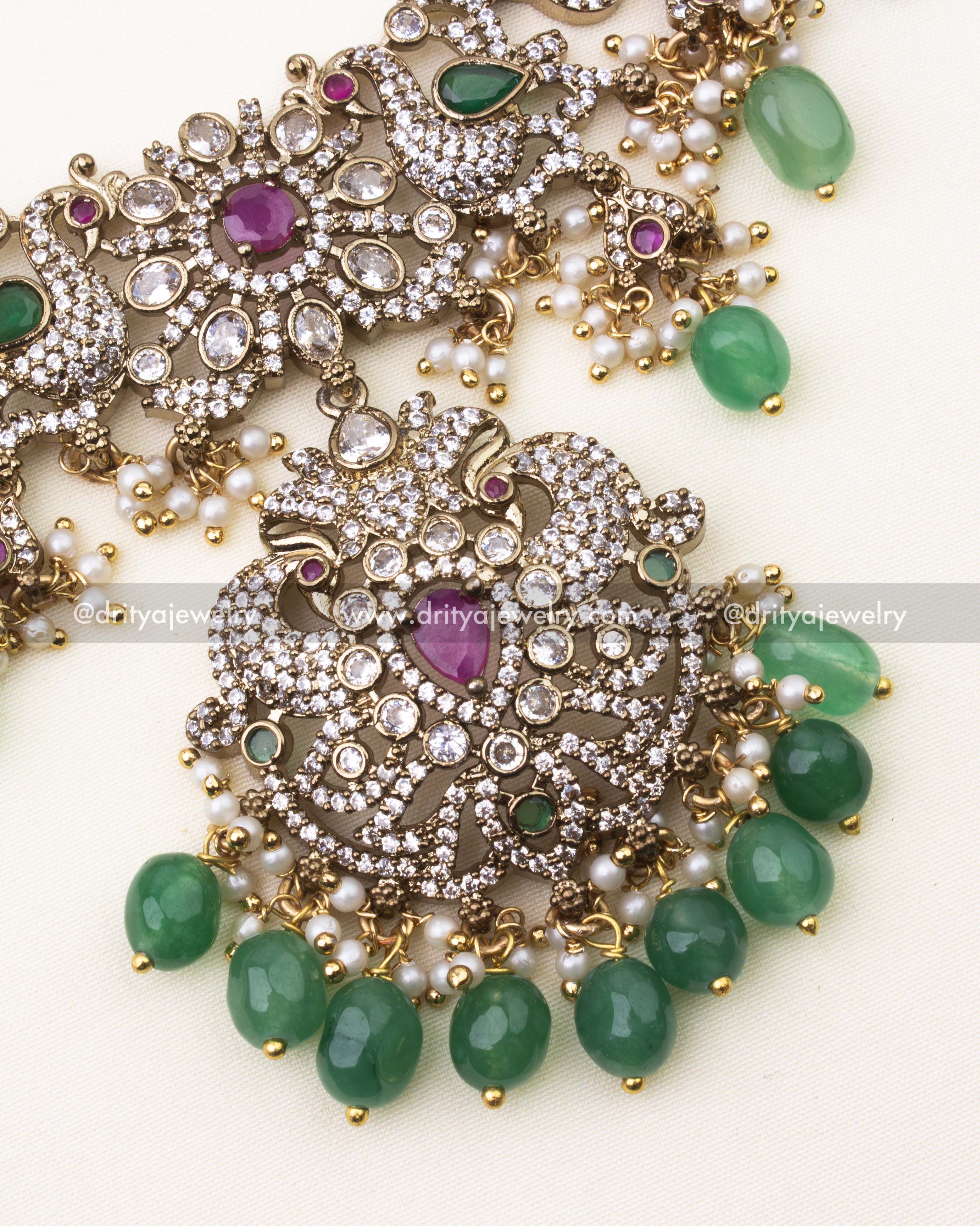 Detailed close-up of Mehndi Victorian pendant featuring ruby stone center, CZ embellishments, and green beads.