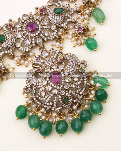 Detailed close-up of Mehndi Victorian pendant featuring ruby stone center, CZ embellishments, and green beads.