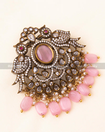 Detailed view of the Victorian pendant with bird motifs, pink center stone, and beaded drops.