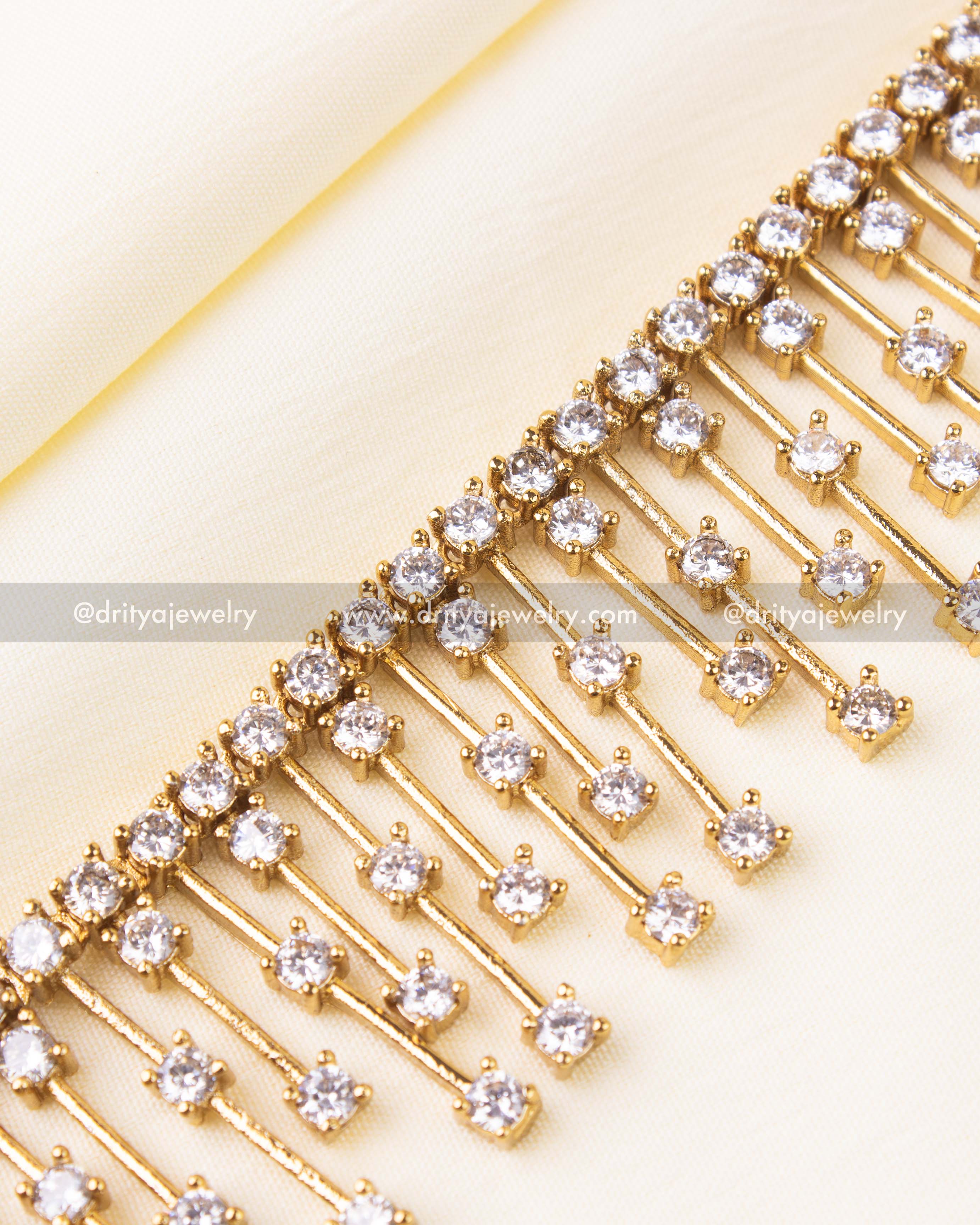 Intricate line-drop necklace with brilliant white CZ stones in a gold setting.