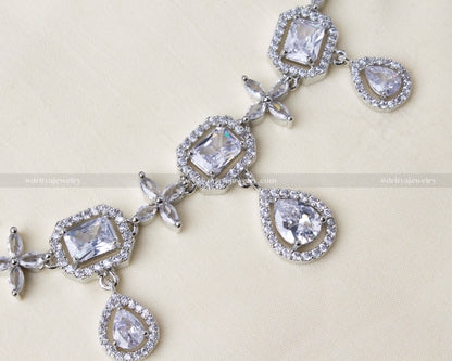 Close-up view showcasing square and pear-cut CZ stones with intricate floral motifs in silver-tone.