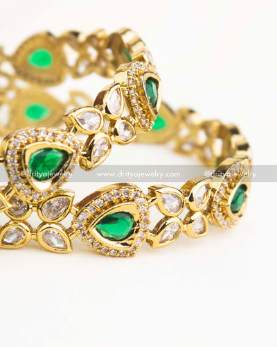 Close-up showing emerald green AD stones bordered with white zircons in Victorian gold finish.