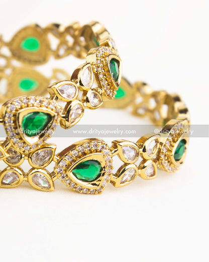 Close-up showing emerald green AD stones bordered with white zircons in Victorian gold finish.
