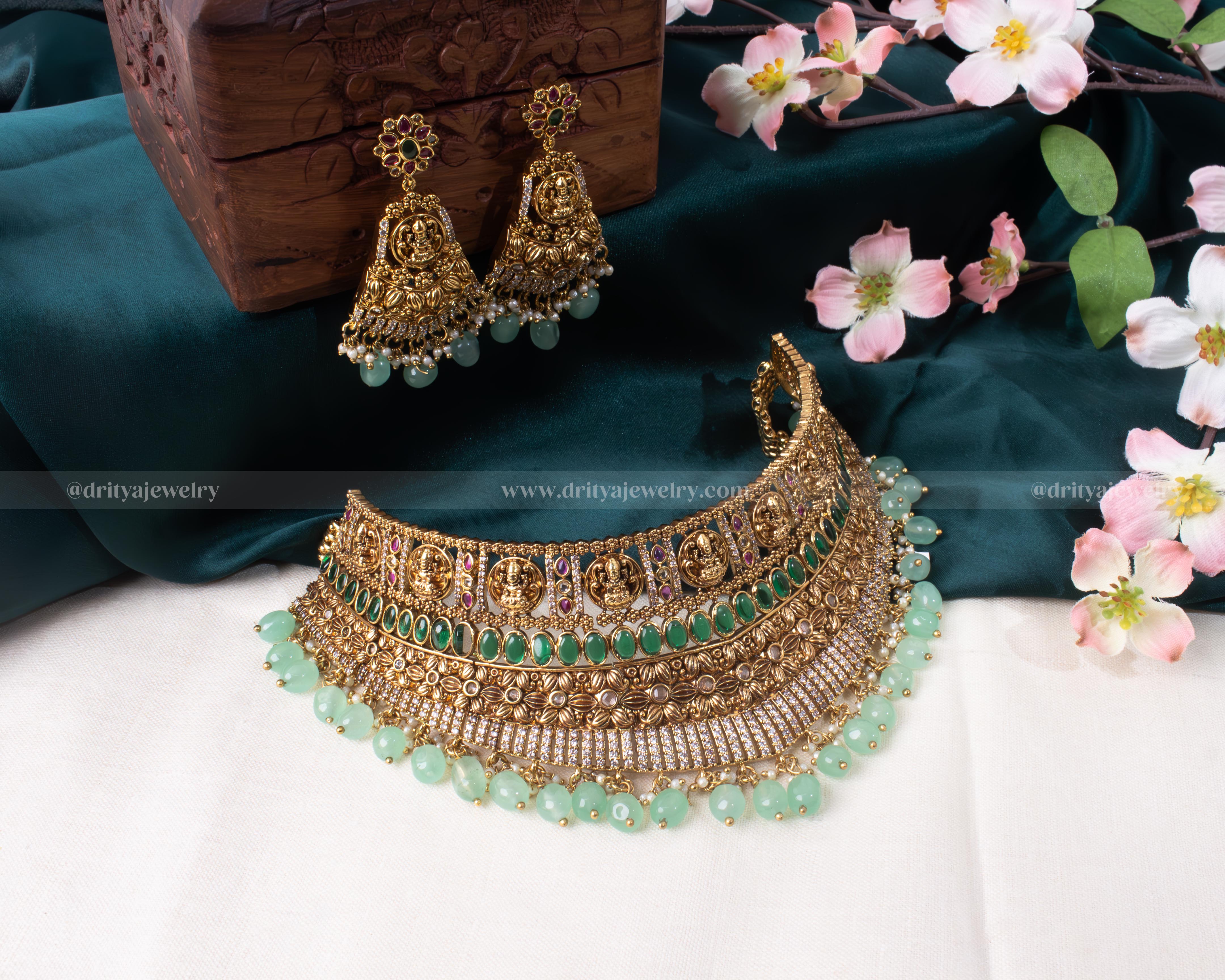 Close-up view showing detailed craftsmanship of Goddess Lakshmi motif on gold choker with green beads by Dritya Jewelry.