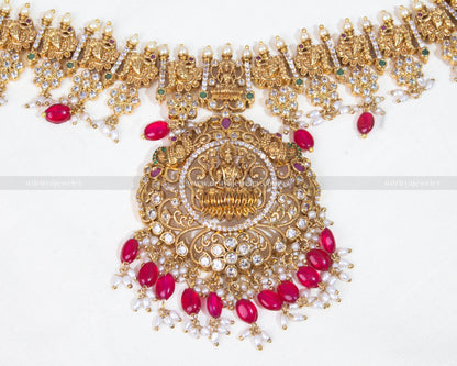 Detailed close-up of the Lakshmi Devi motif encrusted with gemstones on the long Haram necklace, showcasing intricate craftsmanship.