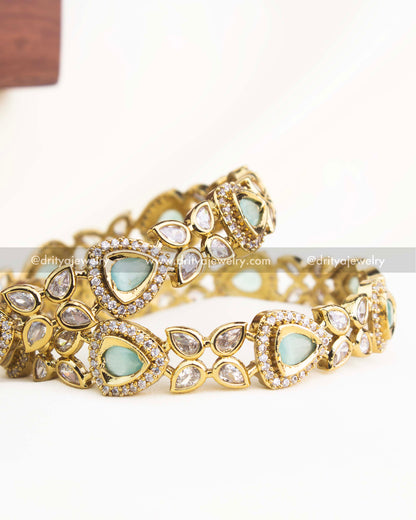 Detailed shot highlighting mint green stones and shimmering AD accents in gold-plated Victorian bangles.