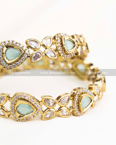 Detailed shot highlighting mint green stones and shimmering AD accents in gold-plated Victorian bangles.