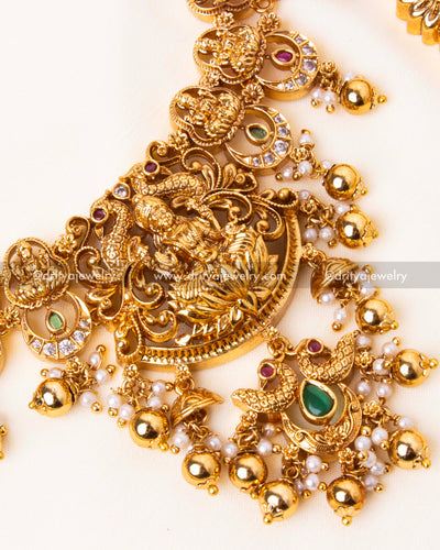 Short Nakshi necklace with floral and deity carvings, adorned with pearls and Kundan stones.