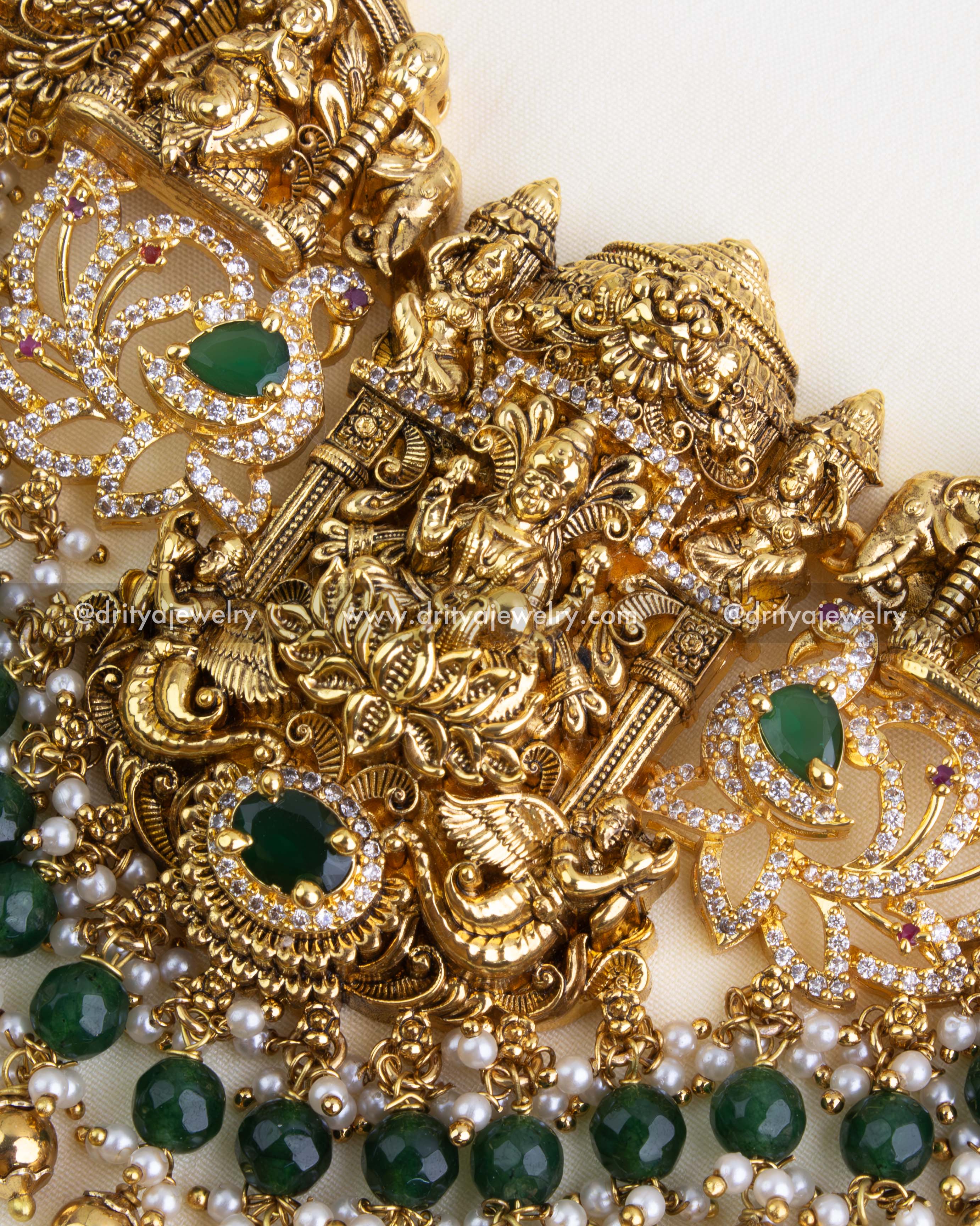 Detailed view of the pendant highlighting Lakshmi Devi, temple structure, green stone accents, and cascading green and pearl bead drops.
