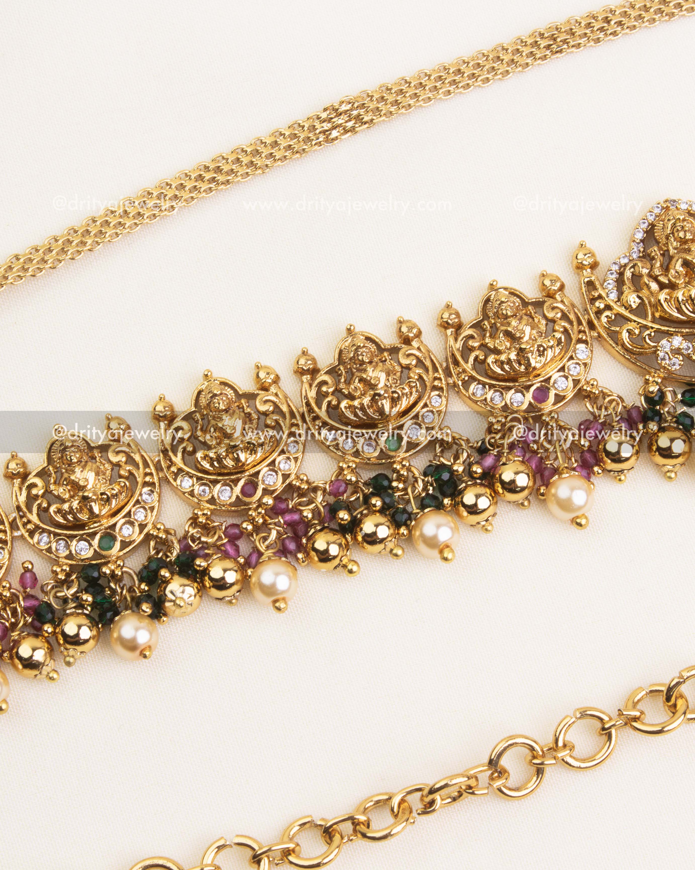 Detailed Nakshi hip chain with ruby and green stone highlights, antique polish, and pearl drops.