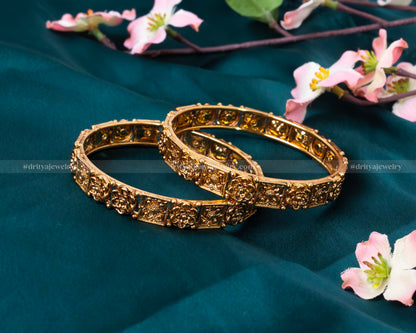 Close-up view of the detailed carvings and antique gold finish on Dritya Jewelry’s openable bangle set.