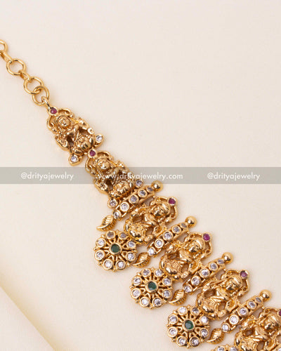 Traditional necklace showcasing floral motifs and goddess figurines with colorful stones.