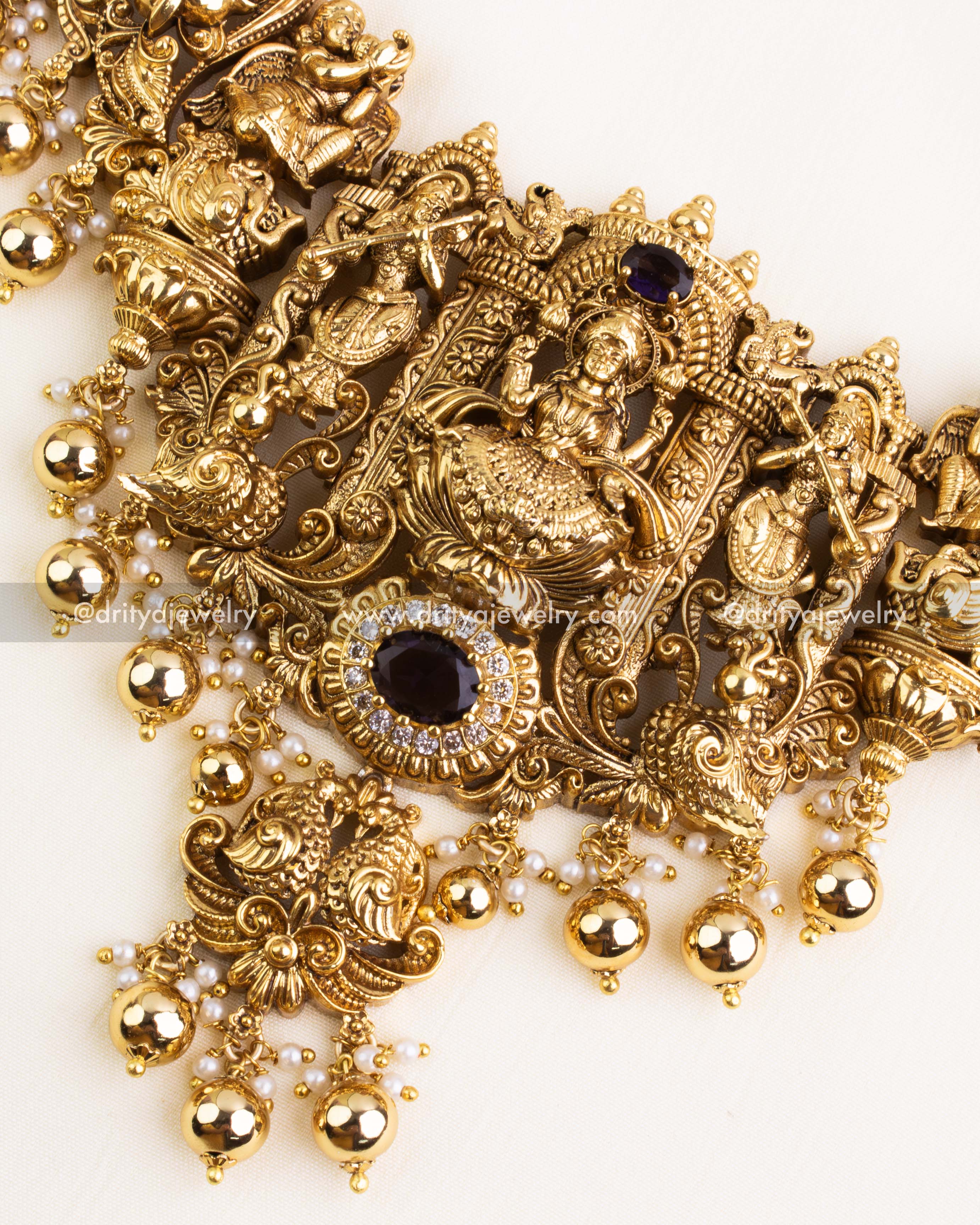 Close-up of Lakshmi Devi pendant showcasing intricate Nakshi carving with purple stone centerpiece and shimmering white CZ stones
