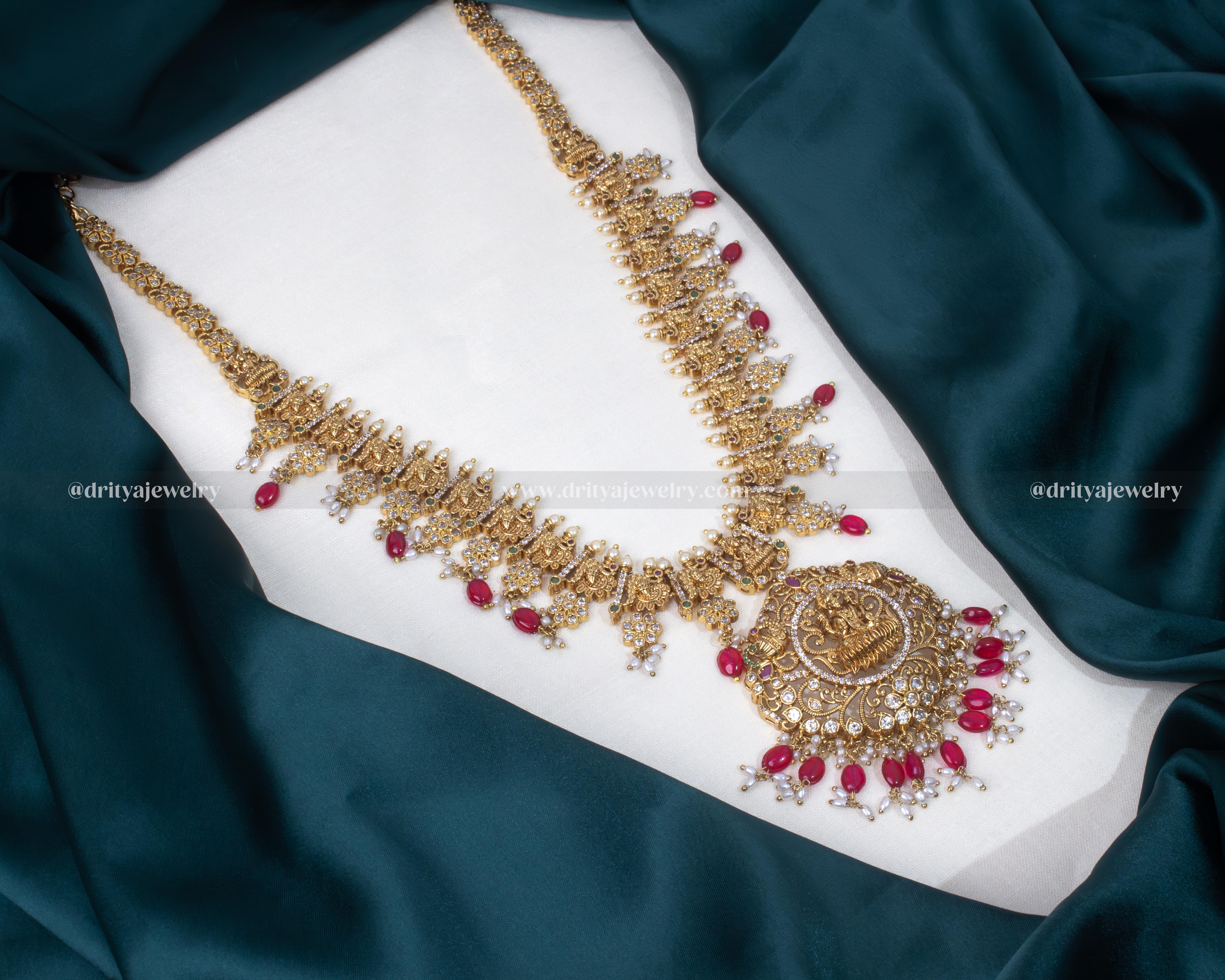 Full view of the Divine Lakshmi Devi Long Haram Necklace set adorned with red gemstones and pearls, perfect for traditional festivities.