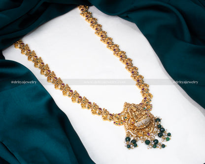 Opulent long Lakshmi Devi necklace set with intricate gold plating and vibrant bead details, ideal for festive and formal occasions.