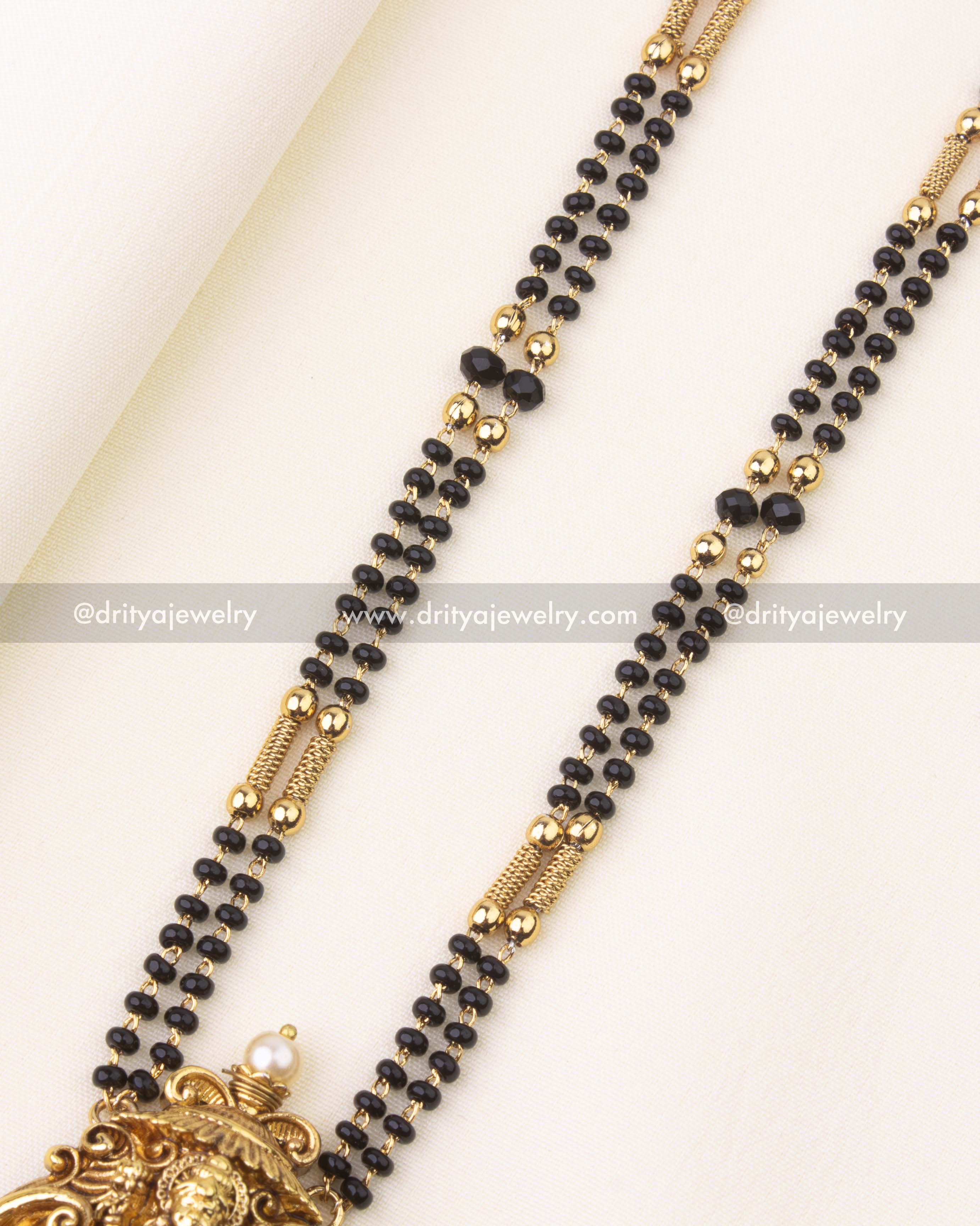 Close-up of black beads double-layer chain with gold separators for traditional necklace design.