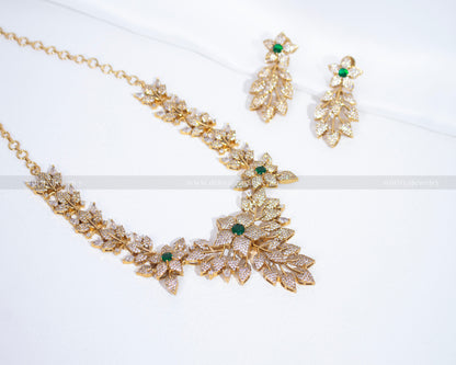 Full view of an intricate floral-designed CZ necklace set from Dritya Jewelry, featuring emerald green accents and matching earrings.