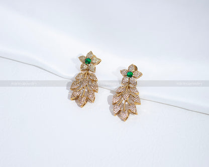 A close-up shot of the matching CZ earrings with floral design and emerald green accents, part of the necklace set from Dritya Jewelry.