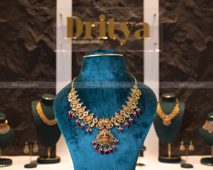 Front view of Dritya Jewelry's Temple Necklace Set with red beads, highlighting intricate temple designs with vibrant stones.