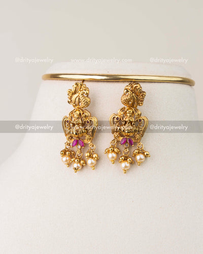 Nakshi temple earrings with Goddess motif, pearl drops, and antique gold polish
