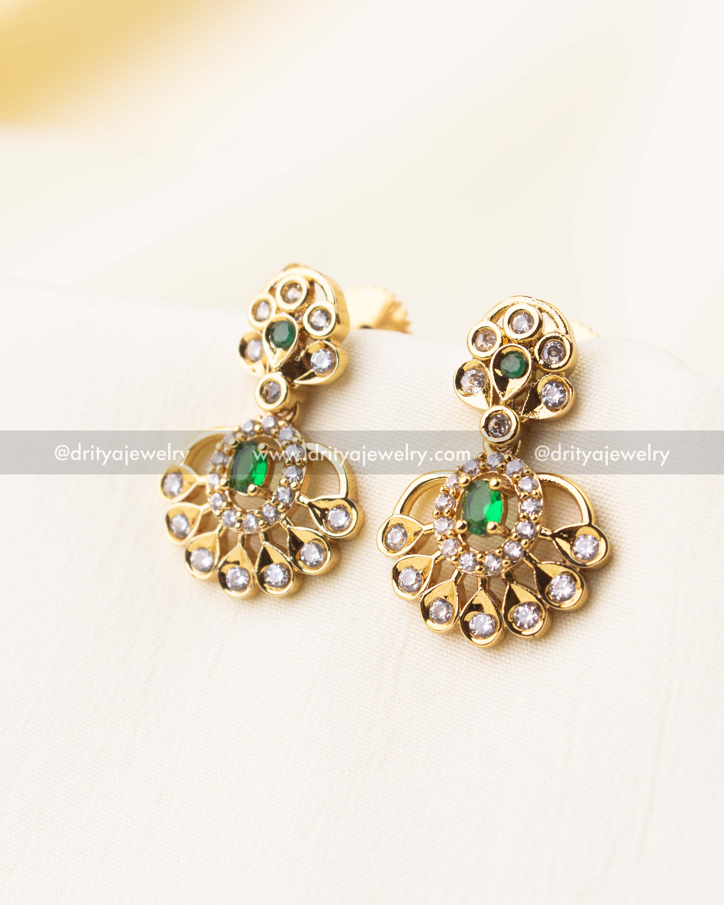 Matching gold earrings with emerald green stone center and studded fan drop.