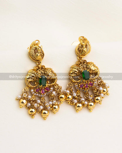 Matching earrings with peacock design, gold bead clusters, and emerald stone centerpiece.