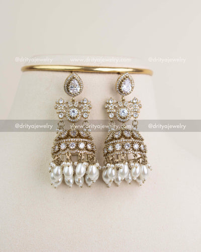 Matching big-size jhumka earrings with Russian emerald stones, AD crystals, and dangling green beads.