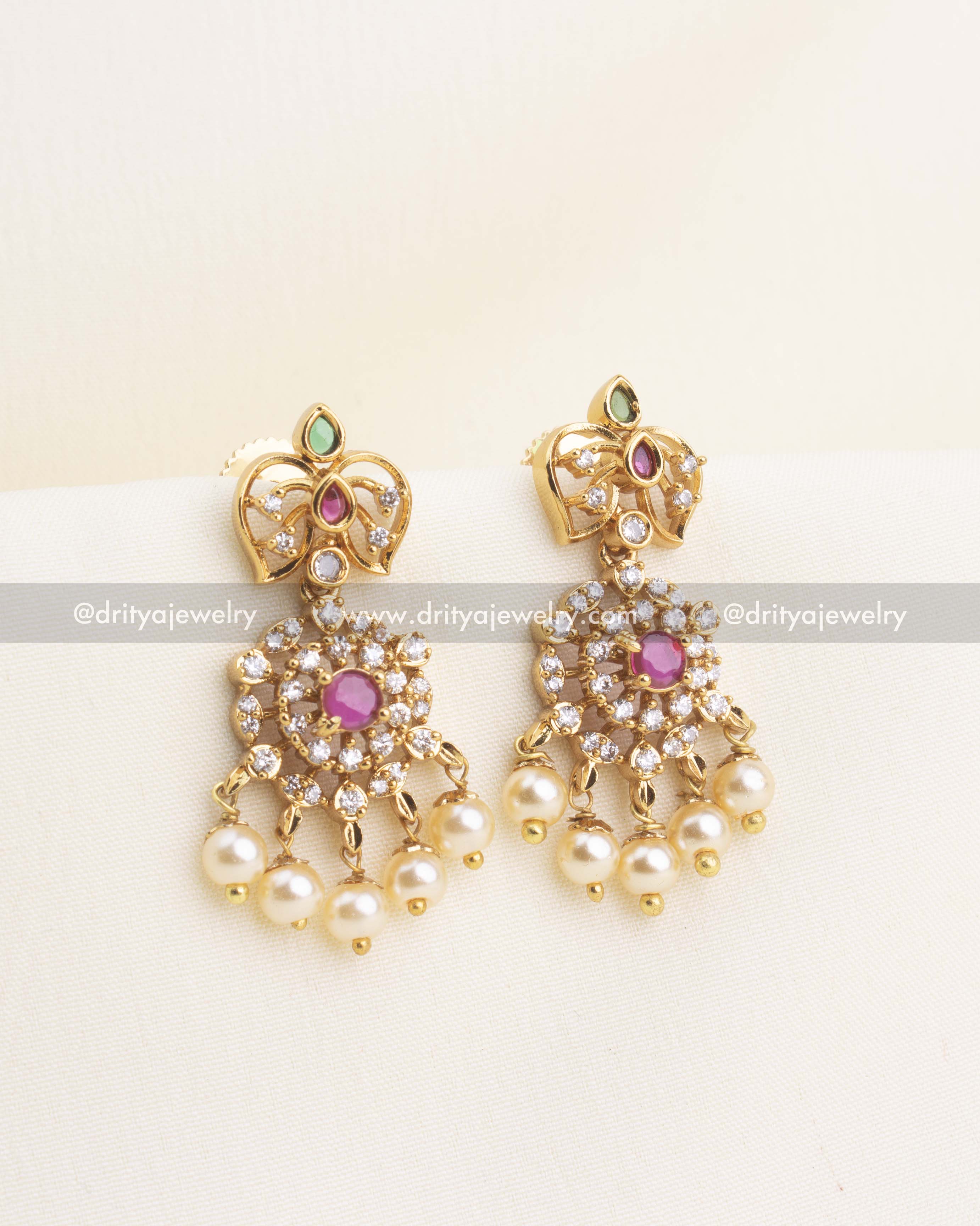 Matching gold replica earrings with ruby stone center, CZ halo, enamel detailing, and pearl hangings.