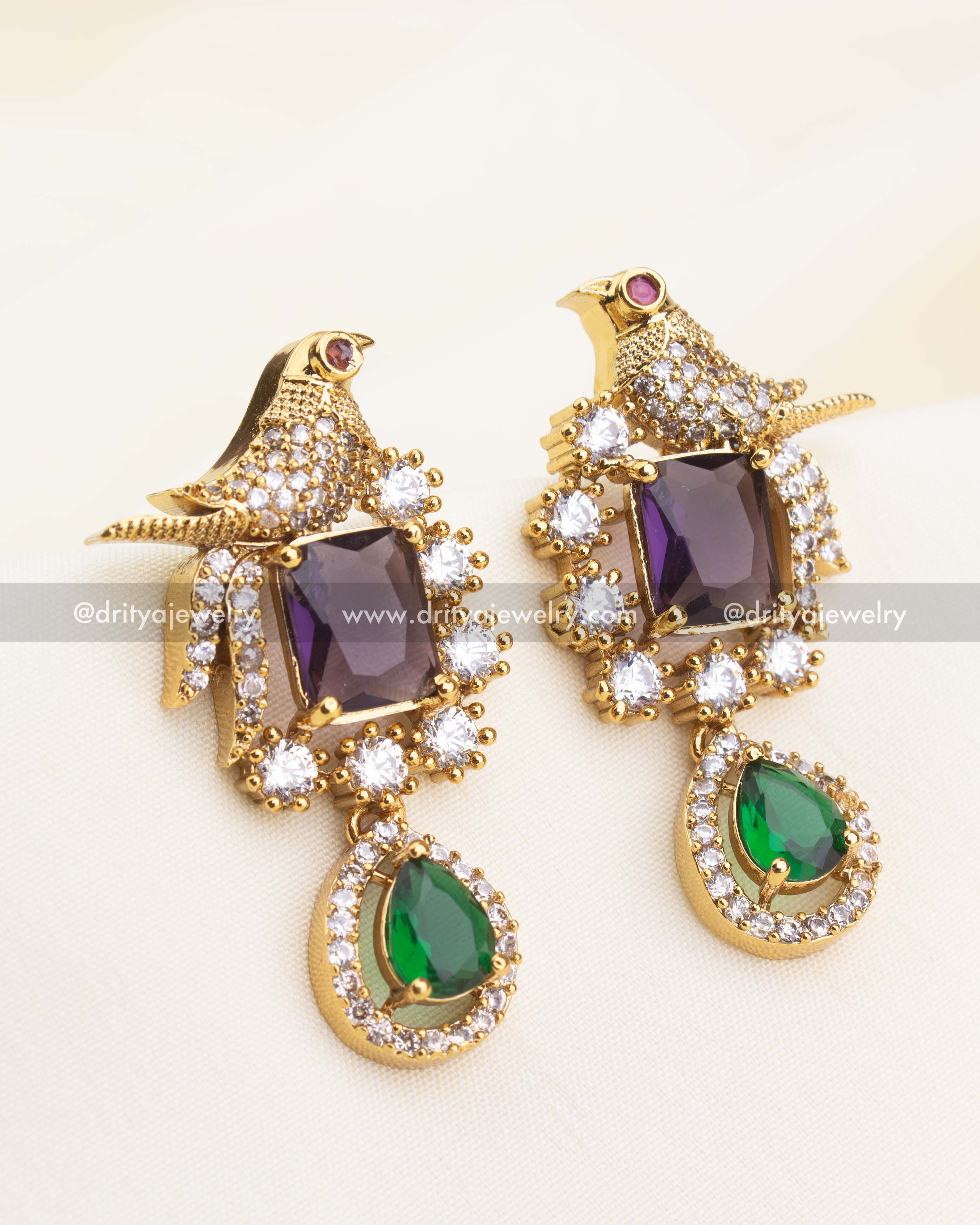 Matching stud earrings with bird detailing, violet centerstones, and green danglers from the CZ necklace set